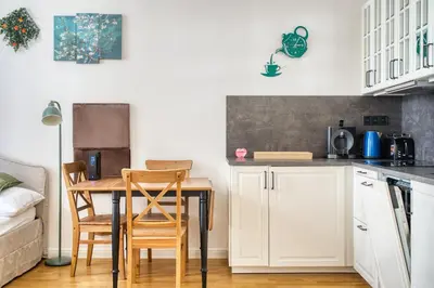 a kitchen with white cabinets and a table and chairs at Cozy Nest by Karlín Square in Prague