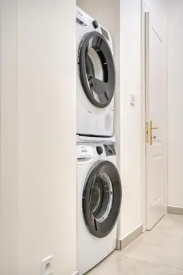 a washer and dryer in a white laundry room at Cozy Nest by Karlín Square in Prague