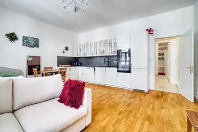a living room with a white couch and a kitchen at Cozy Nest by Karlín Square in Prague