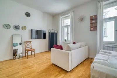 a living room with a white couch and wooden floors at Cozy Nest by Karlín Square in Prague