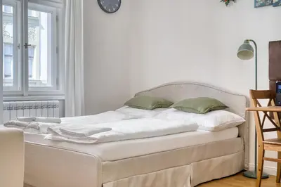 a white bed with two green pillows on it at Cozy Nest by Karlín Square in Prague