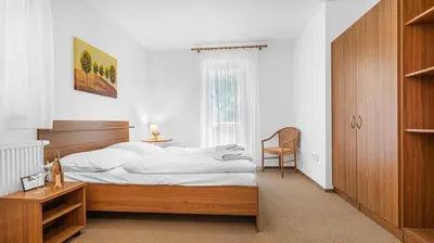 a bedroom with a bed and a desk and a chair at Hotel Samechov - konferenční hotel in Samechov