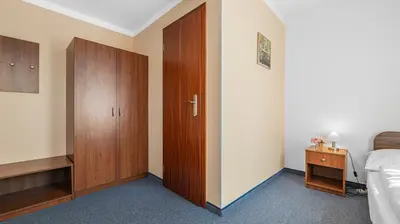a bedroom with a bed and a wooden closet at Hotel Samechov - konferenční hotel in Samechov