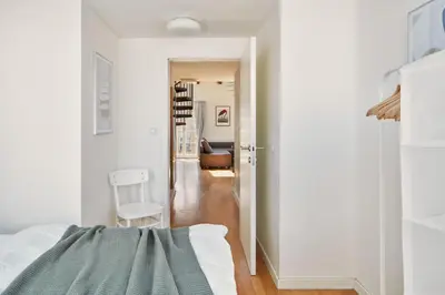 a white bedroom with a bed and a hallway at Prague Days - Maisonette with AC and 2 Bathrooms in New Town in Prague