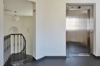 a hallway with a metal door and a staircase at Prague Days - Maisonette with AC and 2 Bathrooms in New Town in Prague