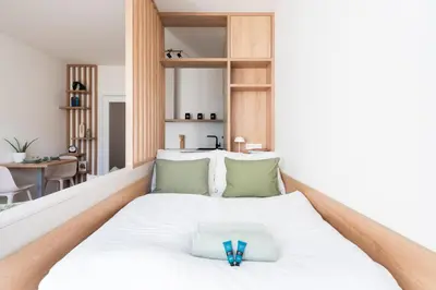 a bedroom with a large white bed with green pillows at Olive Garden Apartment with Garage in Prague