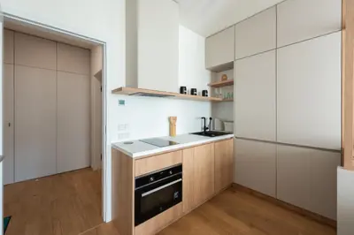 a kitchen with white cabinets and a stove top oven at Olive Garden Apartment with Garage in Prague