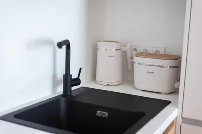 a kitchen counter with a sink and two coffee makers at Olive Garden Apartment with Garage in Prague