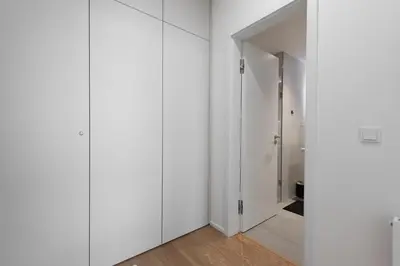 a white room with white cabinets and a hallway at Olive Garden Apartment with Garage in Prague