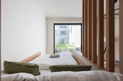a bedroom with two beds and a large window at Olive Garden Apartment with Garage in Prague