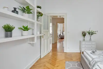 a white living room with plants on shelves at Prague Days - Deluxe Apartment with Balcony overlooking gardens in Lesser Town in Prague