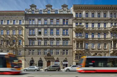 a large building with cars parked in front of it at Prague Days - Deluxe Apartment with Balcony overlooking gardens in Lesser Town in Prague