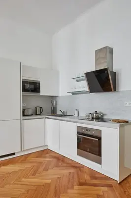 a kitchen with white cabinets and stainless steel appliances at Prague Days - Deluxe Apartment with Balcony overlooking gardens in Lesser Town in Prague