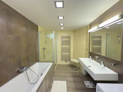 a bathroom with two sinks and a tub and a mirror at Loft-style& Modern Apartment in the center of Prague in Prague