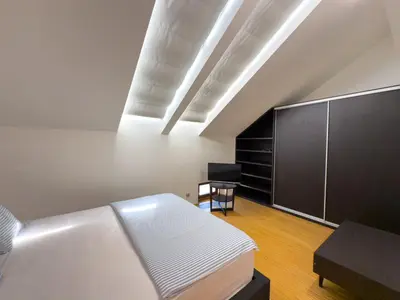 a bedroom with a bed and a black cabinet at Loft-style& Modern Apartment in the center of Prague in Prague