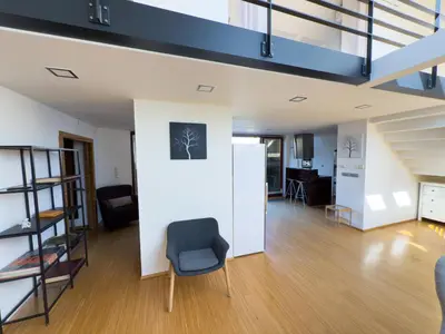 a living room with a staircase and a chair at Loft-style& Modern Apartment in the center of Prague in Prague