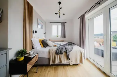 a bedroom with a bed and a large window at Prague Days - Cozy Studio with Rooftop Terrace in hip Letná in Prague