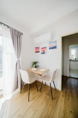 a dining room with a table and white chairs at Prague Days - Cozy Studio with Rooftop Terrace in hip Letná in Prague