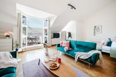 a living room with a blue couch and a table at Prague Days - Loft with Terrace and Prague Castle View by Vltava River in Smíchov in Prague
