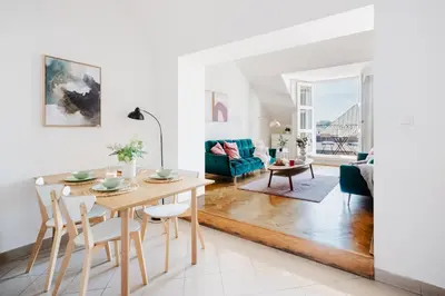 a dining room and living room with a table and chairs at Prague Days - Loft with Terrace and Prague Castle View by Vltava River in Smíchov in Prague