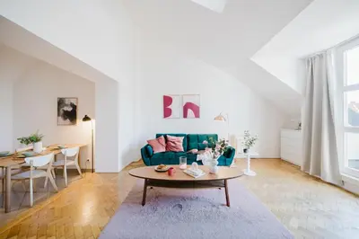 a living room with a blue couch and a table at Prague Days - Loft with Terrace and Prague Castle View by Vltava River in Smíchov in Prague