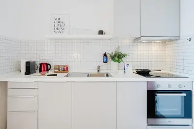 a white kitchen with a sink and a stove at Prague Days - Loft with Terrace and Prague Castle View by Vltava River in Smíchov in Prague