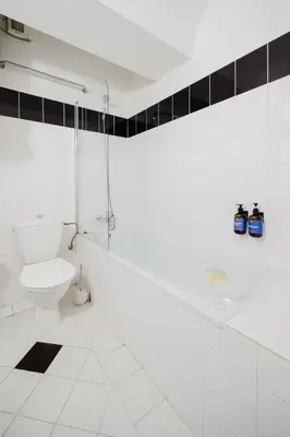 a white bathroom with a toilet and a sink at Prague Days - Loft with Terrace and Prague Castle View by Vltava River in Smíchov in Prague