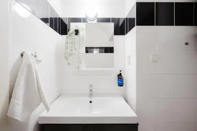 a white bathroom with a sink and a mirror at Prague Days - Loft with Terrace and Prague Castle View by Vltava River in Smíchov in Prague