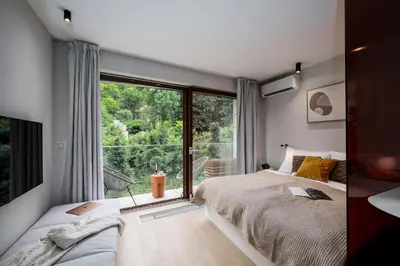 a bedroom with two beds and a large window at Prague Days - Studio with Balcony and Garage Parking in Smíchov in Prague