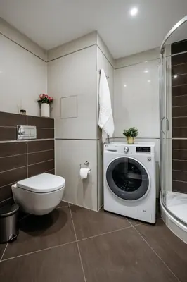 a bathroom with a toilet and a washing machine at Prague Days - Studio with Balcony and Garage Parking in Smíchov in Prague