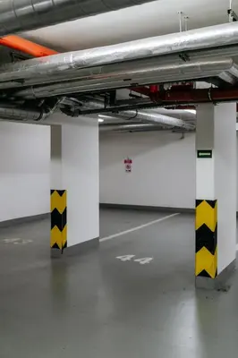 an empty parking garage with yellow and white columns at Prague Days - Studio with Balcony and Garage Parking in Smíchov in Prague