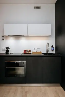 a black kitchen with a sink and a stove at Prague Days - Studio with Balcony and Garage Parking in Smíchov in Prague