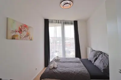 a bedroom with a bed and a large window at Luxury apartment in Smíchov in Prague
