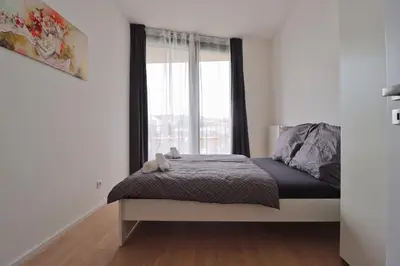a bedroom with a bed and a large window at Luxury apartment in Smíchov in Prague