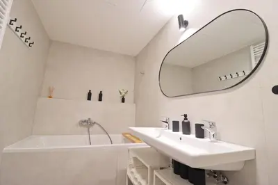 a white bathroom with a sink and a mirror at Luxury apartment in Smíchov in Prague