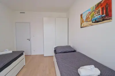 a bedroom with two beds and a painting on the wall at Luxury apartment in Smíchov in Prague