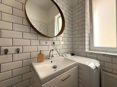 a white bathroom with a sink and a mirror at Peaceful 1Bedroom Flat at Local side of the Center in Prague