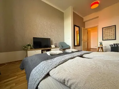 a bedroom with two beds and a flat screen tv at Peaceful 1Bedroom Flat at Local side of the Center in Prague