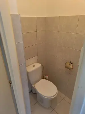 a bathroom with a toilet and a tiled wall at Comfy 2rooms Flat 4 persons & Parking in Prague