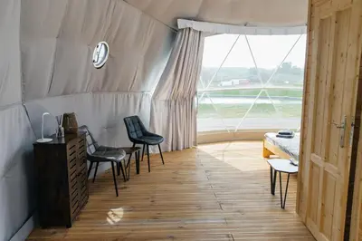 a room with chairs and a table and a window at Glamping Prague Louka in Prague