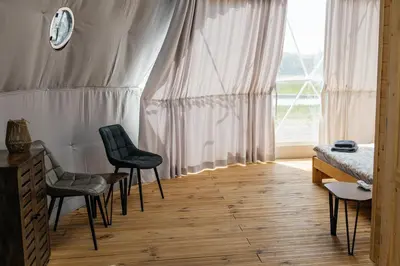 a bedroom with two chairs and a bed and a window at Glamping Prague Louka in Prague