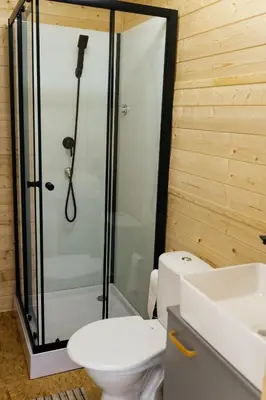 a bathroom with a shower and a toilet and a sink at Glamping Prague Louka in Prague