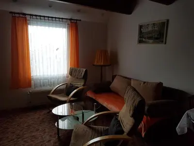 a living room with a couch and chairs and a window at Apartment Příbram in Příbram