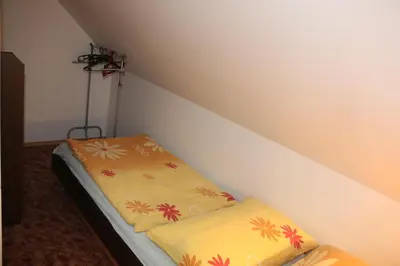 a small room with a bed with flowers on it at Apartment Příbram in Příbram