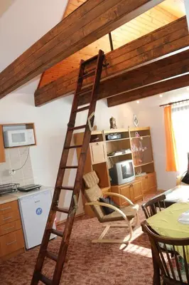 a wooden ladder in a room with a kitchen at Apartment Příbram in Příbram