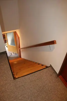 a staircase in a room with a wooden rail on the wall at Apartment Příbram in Příbram