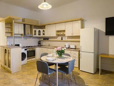 a kitchen with a table with chairs and a refrigerator at Quiet Central Station Apartments in Prague