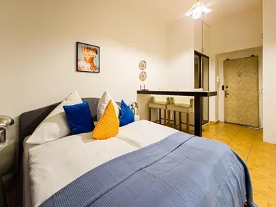 a bedroom with a bed with blue and yellow pillows at Quiet Central Station Apartments in Prague