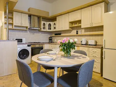a kitchen with a table with chairs and a vase of flowers at Quiet Central Station Apartments in Prague