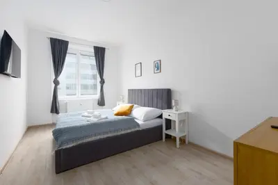 a white bedroom with a bed and a window at Apartment with 2 bedrooms with kitchen near metro in Prague